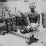 Махатма Ганди преде прежда, снимка от края на 1920 г.