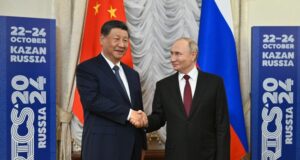 Руският президент Владимир Путин и китайският му колега Си Цзинпин се ръкуват в рамките на среща в кулоарите на форума на БРИКС в Казан