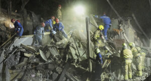 Украински спасители търсят оцелели сред развалините на разрушена сграда при днешната руска ракетна атака срещу Киев.