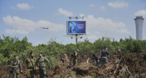 Служители на израелските сили за сигурност инспектират мястото, където ракетата на хусите е оставила кратер край летище "Бен Гурион"