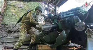 Руски войник подготвя полево оръдие „Хиацинт-Б“ за стрелба срещу украинска позиция