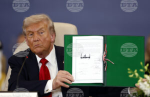 Президентът на САЩ Доналд Тръмп показва подписан документ по време на официална церемония на Международната среща на върха за мир в Газа в Шарм ел Шейх, Египет, 13 октомври 2025 година. Снимка: AP/
