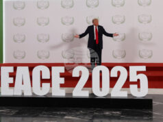 Доналд Тръмп стои на подиум с надпис "Мир 2025" преди началото срещата на световните лидери за прекратяване на войната в Газа