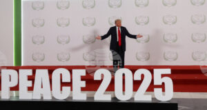 Доналд Тръмп стои на подиум с надпис "Мир 2025" преди началото срещата на световните лидери за прекратяване на войната в Газа