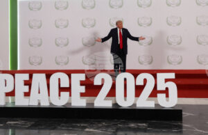 Доналд Тръмп стои на подиум с надпис "Мир 2025" преди началото срещата на световните лидери за прекратяване на войната в Газа