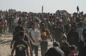 Палестинци носят кутии с храна, доставени от "Хуманитарната фондация в Газа" в град Рафах