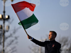 идерът на унгарската опозиция Петер Мадяр развява знамето на Унгария по време на предизборно събитие в Будапеща, 15 март 2026 година.