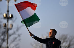 идерът на унгарската опозиция Петер Мадяр развява знамето на Унгария по време на предизборно събитие в Будапеща, 15 март 2026 година.